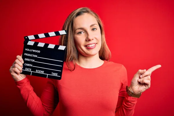 Jovem Bela Mulher Clapper Loira Segurando Clapboard Sobre Fundo Vermelho — Fotografia de Stock