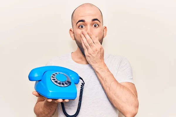 Genç Kel Bir Adam Elinde Antika Bir Telefonla Ağzını Eliyle — Stok fotoğraf