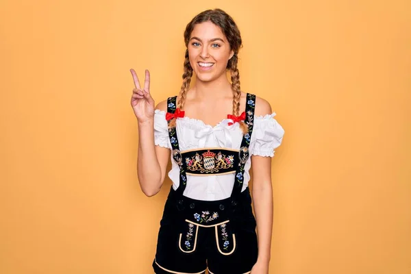 年轻美丽的金发德国女人 蓝眼睛 身穿传统的十月节礼服 手指点点二号 面带微笑 自信而快乐 — 图库照片