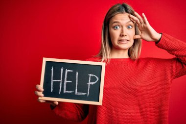 Karatahta tutan genç ve güzel bir kadın. Kırmızı arka plan üzerinde duruyor. Elleri başının üstünde, utanç ve şaşkınlık dolu, sinirli ve hayal kırıklığına uğramış bir halde. Hata için korku ve üzüntü.