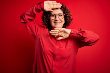 Orta yaşlı, kıvırcık saçlı, rahat gömlekli, kırmızı arka planda gözlüklü neşeli gülümseyen, elleri havada bir kızı dikizleyen güzel bir kadın. Şaşırdım ve çıktım.