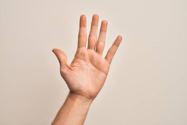 İzole edilmiş beyaz arka planda parmaklarını gösteren beyaz bir adamın eli 5 numarayı gösteriyor.