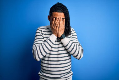 Rasta desenli çizgili süveter giyen, elleri ağlarken yüzünü ellerle kapatan Afro-Amerikan genç yakışıklı adam. Depresyon kavramı.