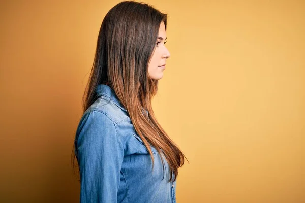 Junges Schönes Mädchen Trägt Lässiges Jeanshemd Das Über Isoliertem Gelbem — Stockfoto