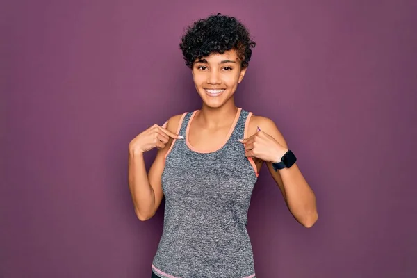 年轻美丽的非洲裔美国女运动员穿着运动服做运动 面带微笑 看上去很自信 用手指指着自己 自豪而快乐 — 图库照片