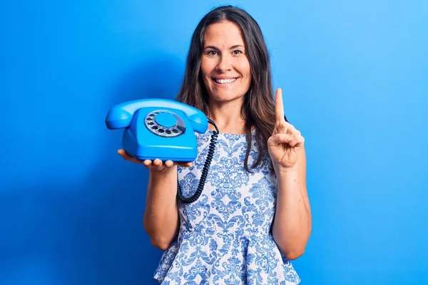 Jovem Bela Morena Mulher Segurando Telefone Vintage Sobre Fundo Azul — Fotografia de Stock