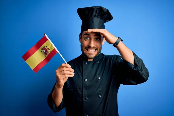 Mladý Pohledný Kuchař Plnovousem Uniformě Držící Španělskou Vlajku Vystresovaný Rukou — Stock fotografie