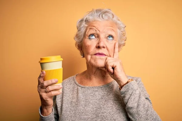 Starsza Piękna Kobieta Pijąca Kawę Stojąca Nad Odizolowanym Żółtym Tłem — Zdjęcie stockowe