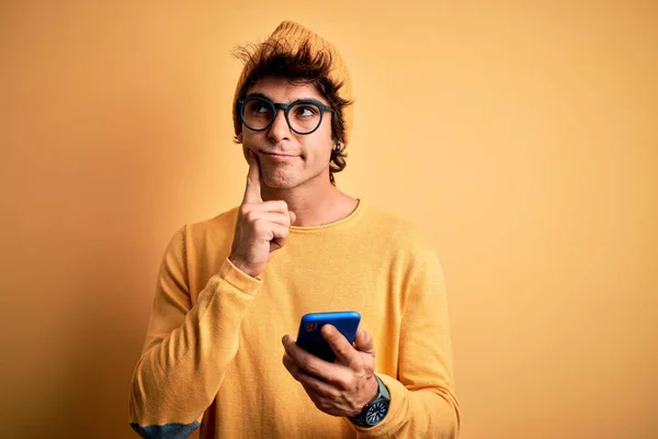 Ung Stilig Man Med Smartphone Bär Glasögon Över Isolerad Gul — Stockfoto