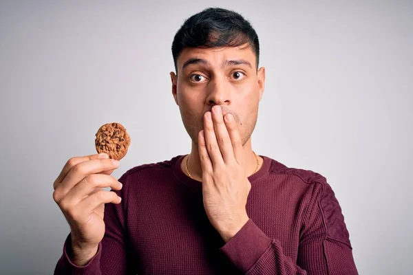 Ung Latinamerikansk Man Äter Choklad Chips Kaka Över Isolerad Bakgrund — Stockfoto