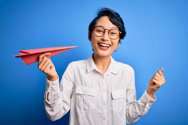 Jovem Mulher Chinesa Bonita Segurando Avião Papel Sobre Fundo Azul — Fotografia de Stock