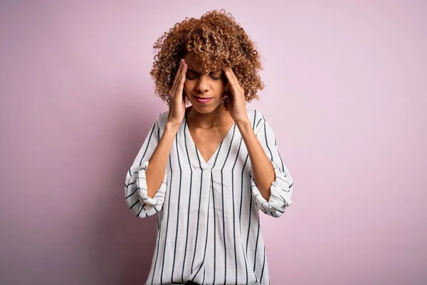 美丽的非洲裔美国女人 带条纹的T恤 粉色背景 手头上有疼痛 因为压力 痛苦的偏头痛 — 图库照片