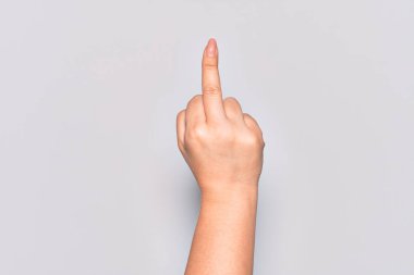 Hand of caucasian young woman showing provocative and rude gesture doing fuck you symbol with middle finger