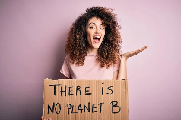 Young beautiful activist woman with curly hair and piercing protesting asking for change planet very happy and excited, winner expression celebrating victory screaming with big smile and raised hands