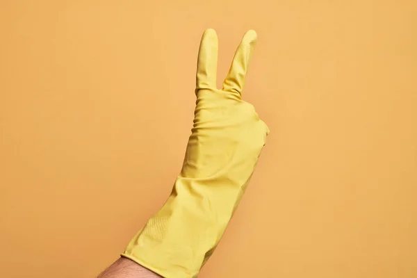 Mano Del Joven Caucásico Con Guante Limpieza Sobre Fondo Amarillo —  Fotos de Stock