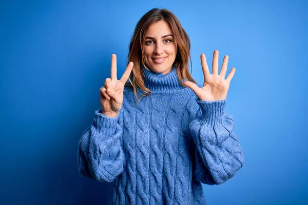 Junge Schöne Brünette Frau Trägt Lässigen Rollkragenpullover Über Blauem Hintergrund — Stockfoto