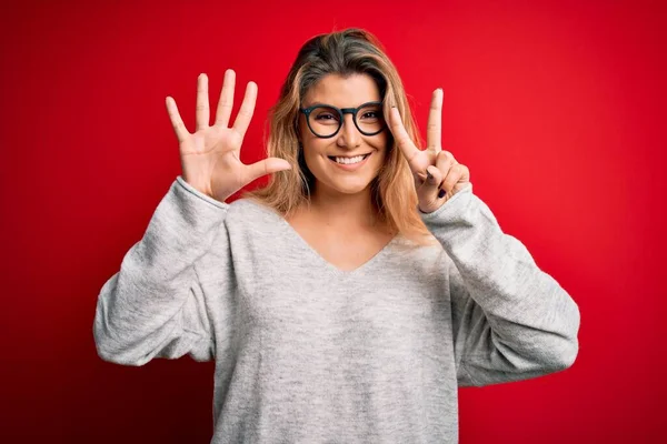 Jovem Mulher Loira Bonita Vestindo Suéter Óculos Sobre Fundo Vermelho — Fotografia de Stock