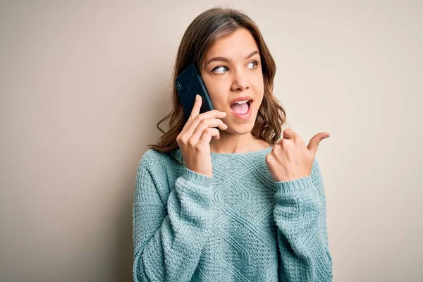 Young Blonde Girl Having Conversation Talking Smartphone Isolated Background Pointing — Stock Photo, Image