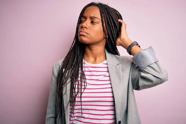 ピンク色の隔絶された背景の上に立っている若いアフリカ系アメリカ人のビジネス女性は混乱し 疑問に思う 疑いもなく 頭の上で手で考えて 包括的概念 — ストック写真