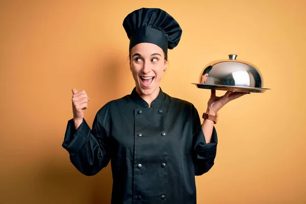 年轻美丽的厨师女士身穿炊事服 头戴圆顶圆顶圆顶的帽子 笑容满面地站在一旁 — 图库照片
