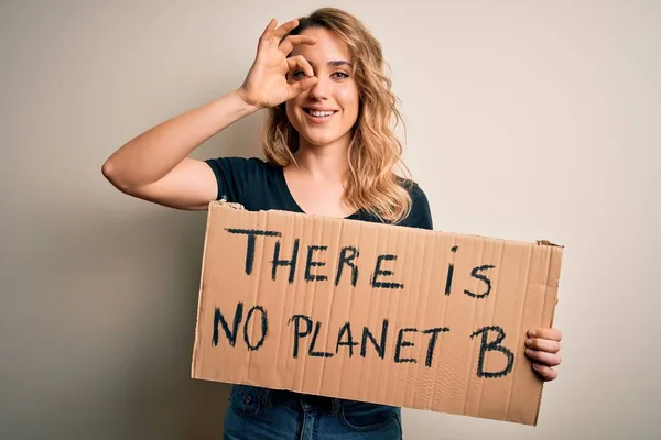 若いですブロンドアクティビスト女性要求環境保持バナーとともに惑星メッセージとともに幸せな顔笑顔行いますOk Signとともに手で目を通して指を見て — ストック写真