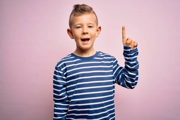 青い目の若い白人の子供は ピンクの背景の上にネイビーのストライプのシャツを着て 成功したアイデアで指を指しています 興奮し 第一番 — ストック写真