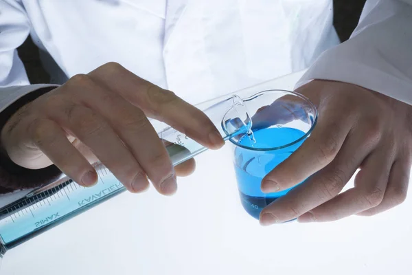 化学实验室 将蓝色液体倒入毕业玻璃 — 图库照片