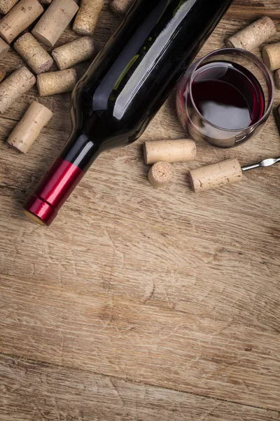 Botella de vino tinto, vidrio y corchos — Foto de Stock