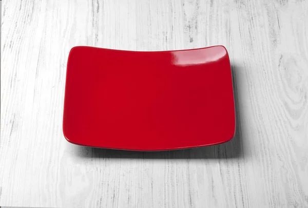 Plato rojo sobre una mesa — Foto de Stock