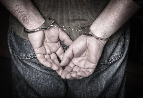 Мужские руки в наручниках — стоковое фото