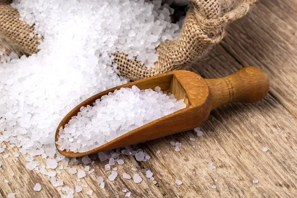Mořská sůl v sáčku a s dřevěnou lžící — Stock fotografie