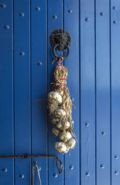 Trenza de ajo en una puerta azul — Foto de Stock