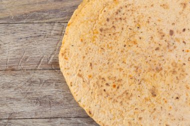 Tahta masa arkasında ev yapımı tam buğday unlu tortilla yığını