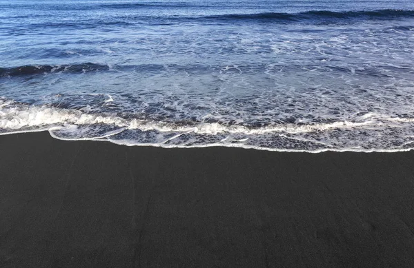 带波浪泡沫纹理的黑沙滩 — 图库照片
