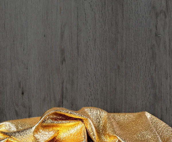 Dunkle Holzstruktur mit goldenem Textil, — Stockfoto