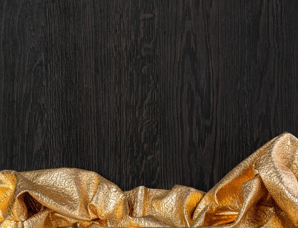Dunkle Holzstruktur mit goldenem Textil — Stockfoto