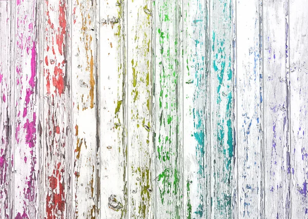a rainbow drawn through white paint on old wooden planks background
