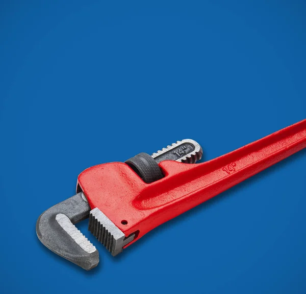 Большой гаечный ключ с красной ручкой на голубом — стоковое фото