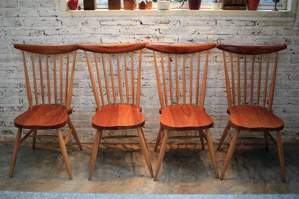 Cadeiras de madeira no quarto com parede de tijolo — Fotografia de Stock