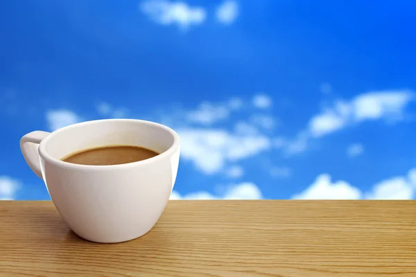 Una taza de café sobre la mesa sobre el fondo del cielo — Foto de Stock