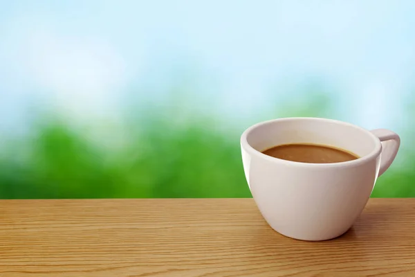 A cup of coffee on table over green background — Stock Photo, Image