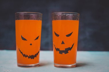Cadılar Bayramı için balkabağı ve kurabiye dolu bardaklar.