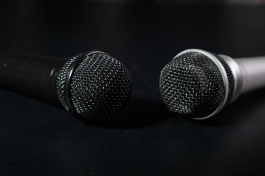 two microphones lie on a black background