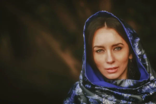 stock image woman in black dress and shawl near a tree