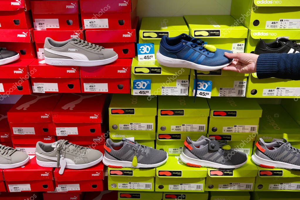 THE NETHERLANDS - APRIL 2018: Puma and Adidas brand sneakers in a sportswear shop.
