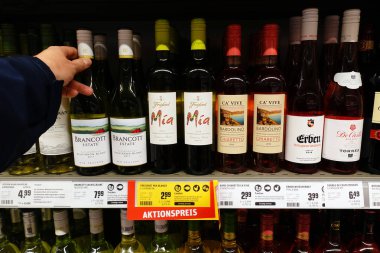 Almanya - Aralık 2019: İspanyol, İtalyan, Yeni Zelanda ve Portekiz şarap şişeleri bir dükkanda. Rewe süpermarketinde farklı kökenden gelen çeşitli şaraplar..