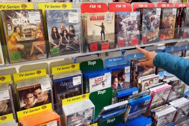 Monschau, Almanya - Temmuz 2015: Blu-ray Diskler ve DVD 'ler bir mağazada. Müşteri Gerçek bir hipermarketin medya koridorundan DVD seçiyor.