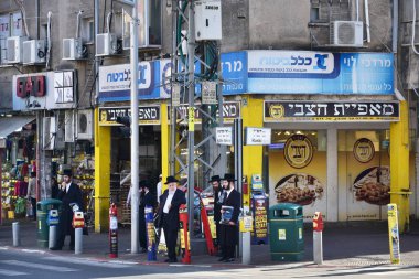 Bnei Brak, İsrail - Aralık 2019: Bnei Brak 'ta günlük yaşam. Chassidim pastanenin yanında Haham Akiva caddesini geçmek için yaya geçidi bekliyor..