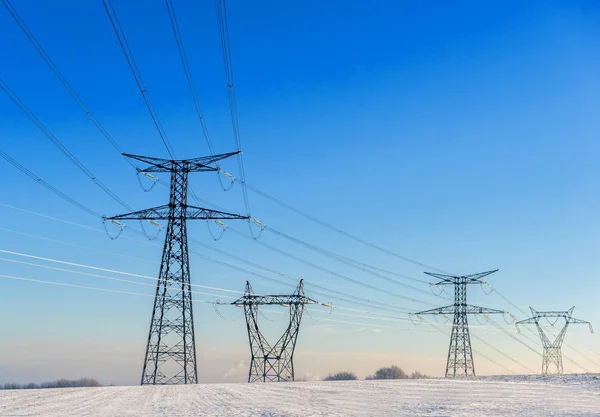 Líneas eléctricas en un paisaje nevado Imagen de stock