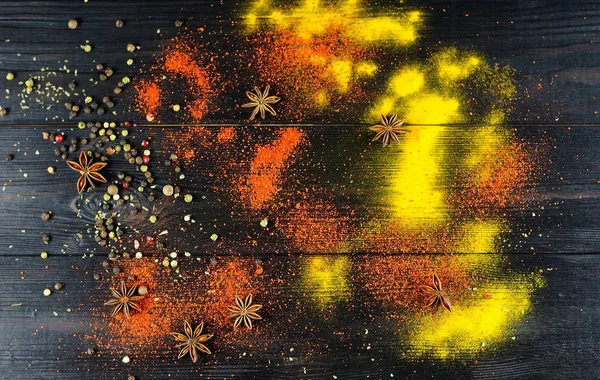 Cúrcuma especia, pimentón y pimienta de color dispersos sobre un fondo oscuro — Foto de Stock